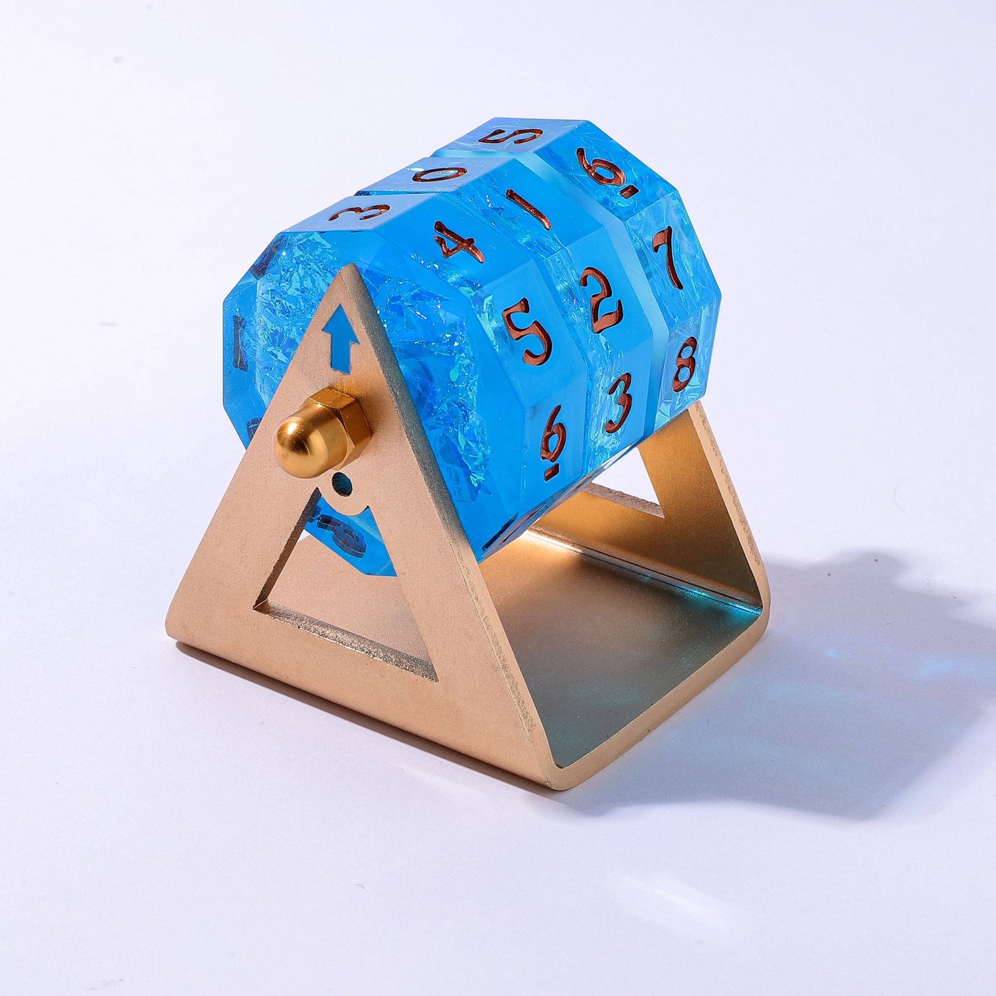 Blue acryllic spinnable life counter with gold stand on a white background